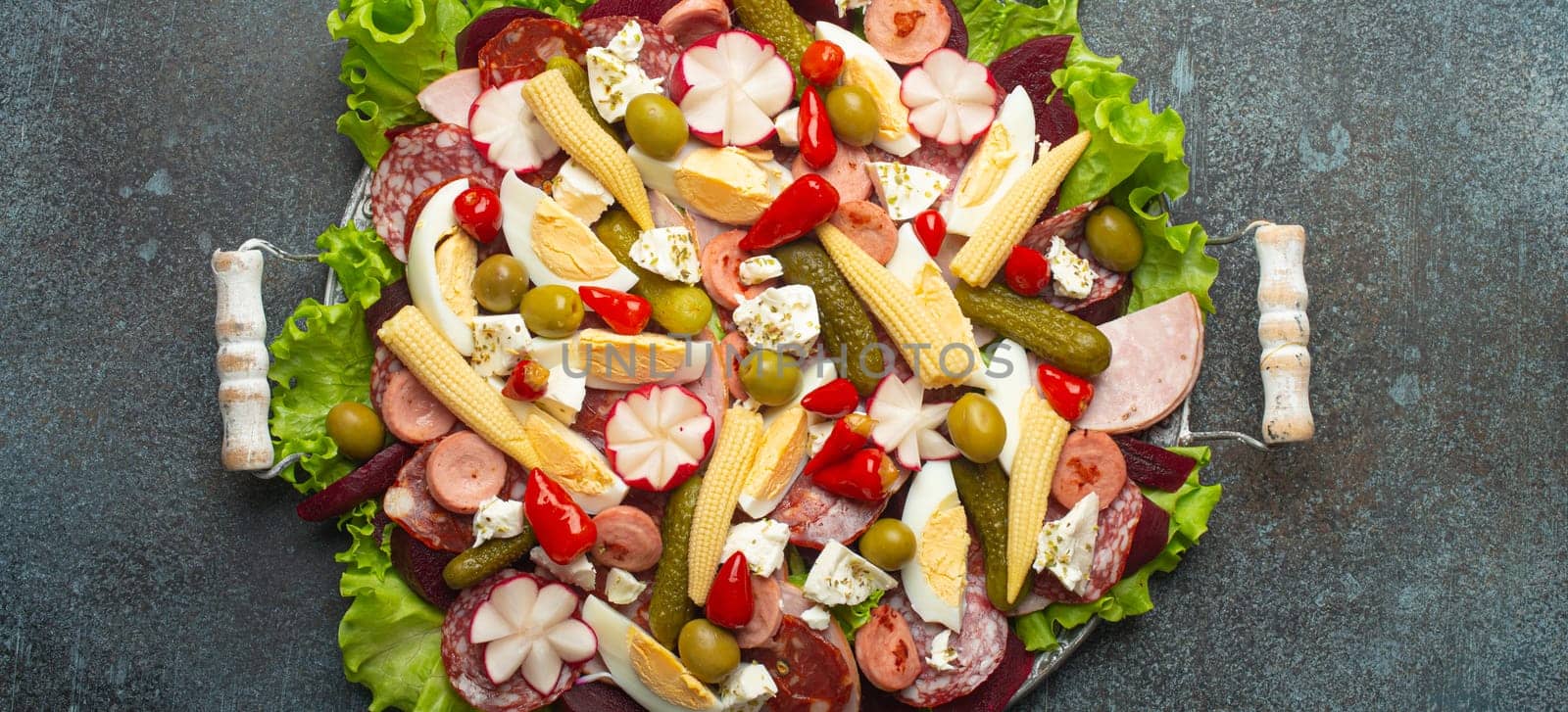Fiambre, salad of Guatemala, Mexico and Latin America, served on large plate top view. Festive dish for All Saints Day (Day Of The Dead) celebration made of cold cuts, sausages, pickled vegetables.
