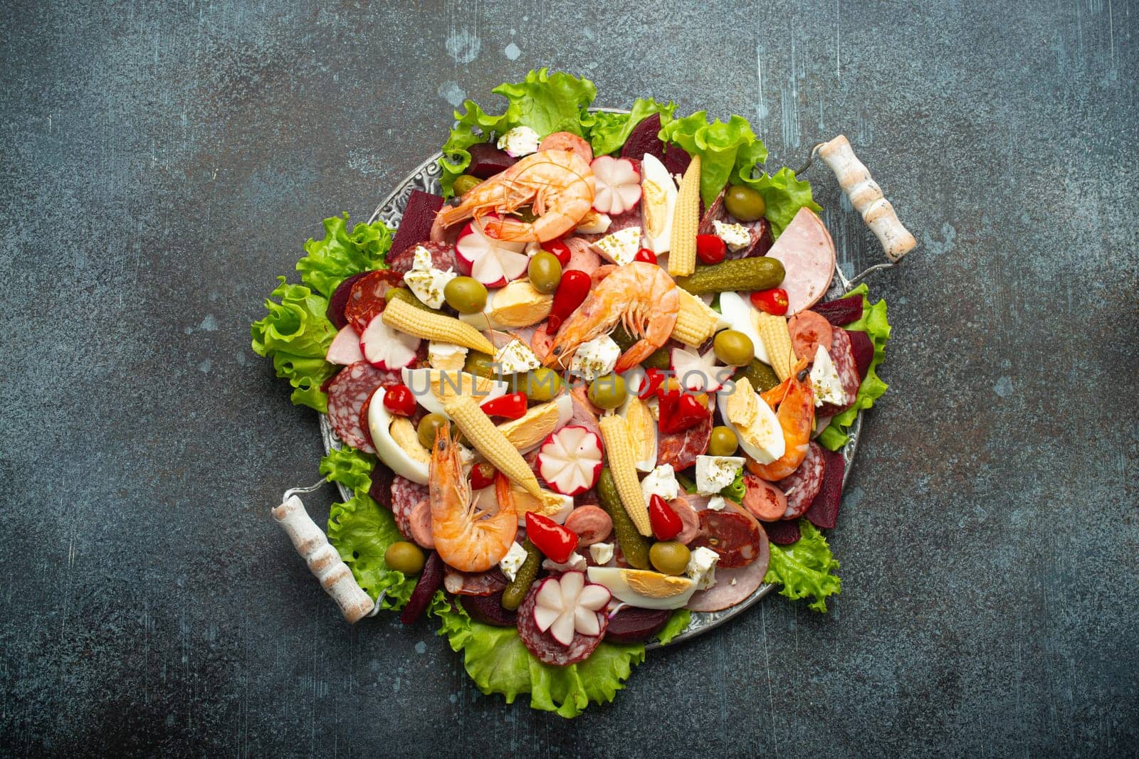 Fiambre, salad of Guatemala, Mexico and Latin America, on large plate top view white wooden background top view with cold cuts, shrimps. Festive dish for All Saints Day (Day Of The Dead) celebration.