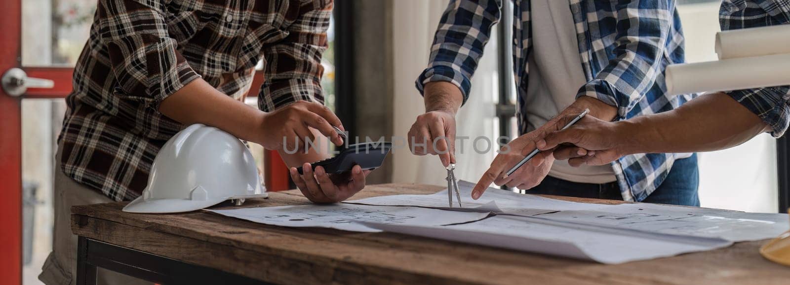 Team of civil engineers meeting at construction site in modern city To plan the work and layout of the project. by wichayada