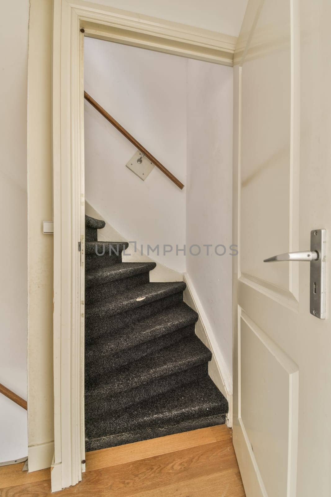 an empty room with stairs and a door leading to the second floor, which is in need of repair work