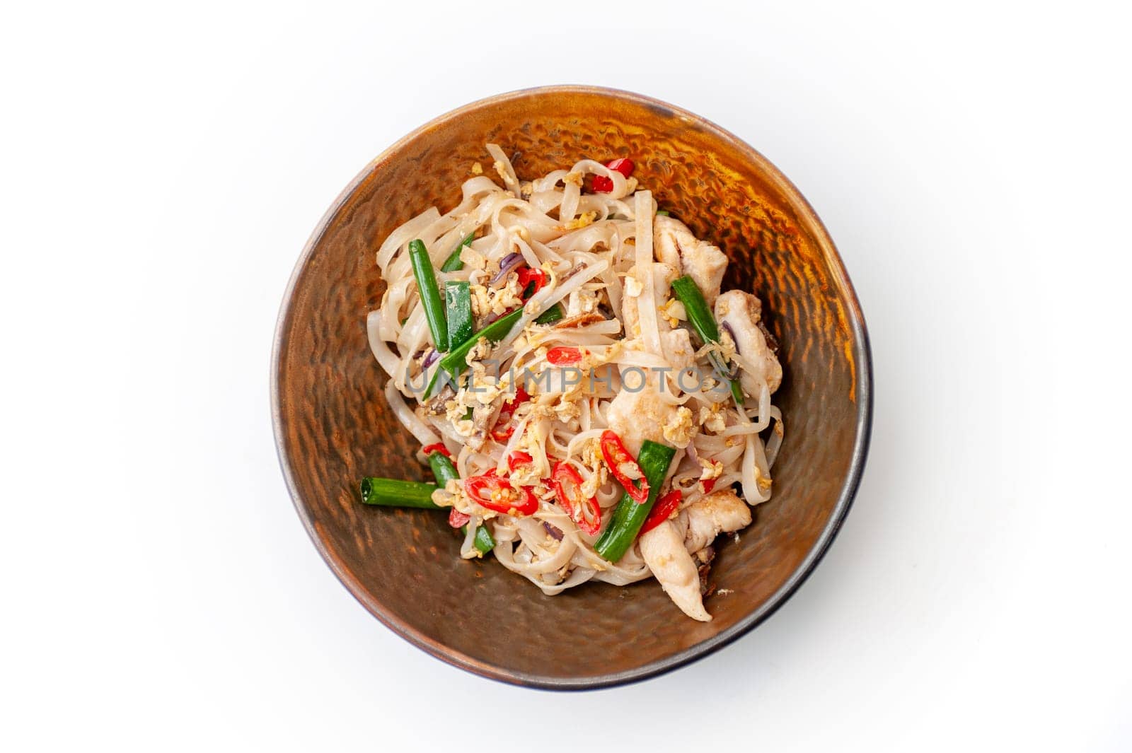 Pad Thai Udon noodles in in a brown plate, top view isolated. Food in asian style. High quality photo.