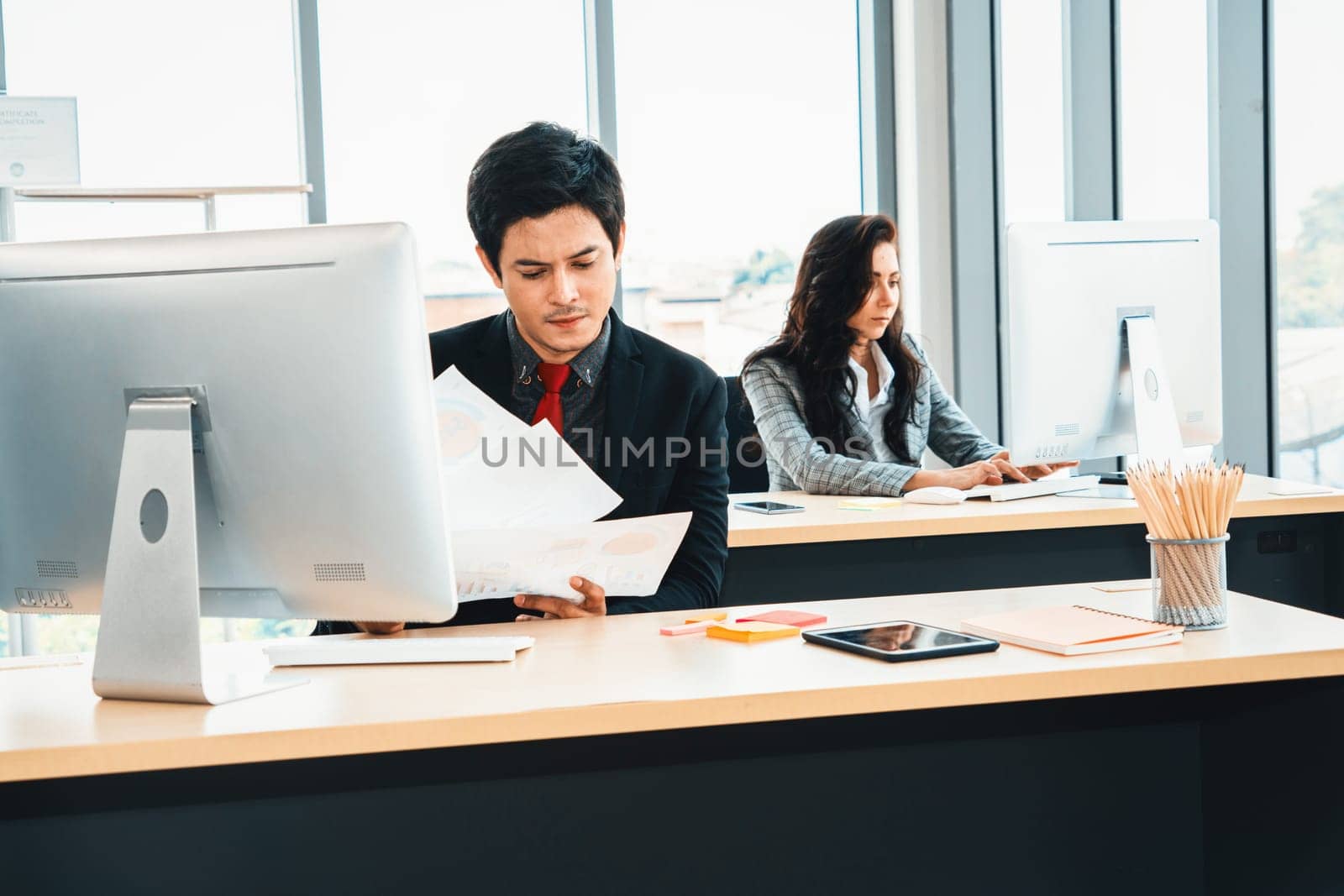 Business people working at table in modern office room while analyzing financial data report . Jivy