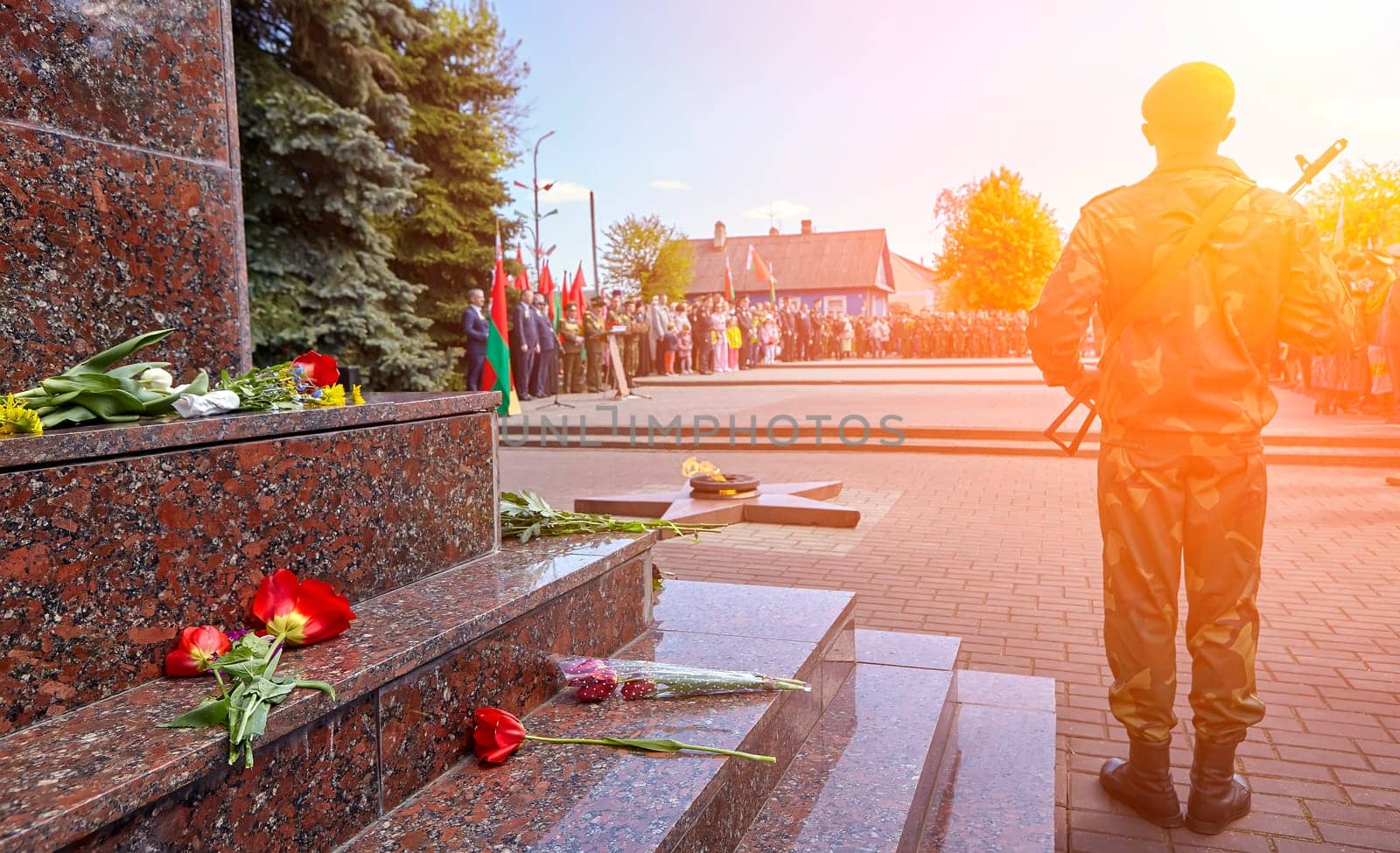 Honor guard at the monument to soldiers killed in the Second World War. A soldier with a rifle laying flowers.
