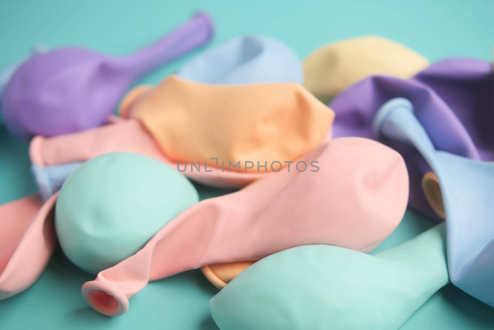 A vibrant and colorful collection of pastel latex balloons beautifully arranged on a teal surface