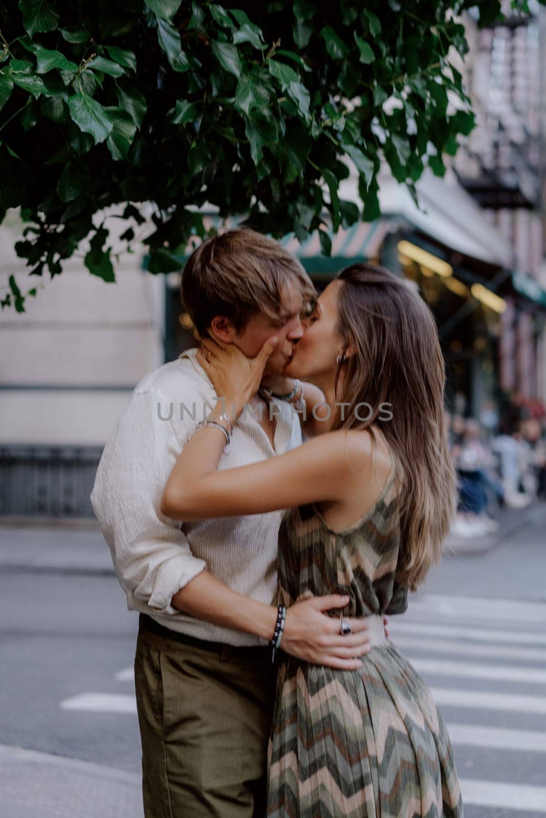 A couple lovingly shares a tender embrace in front of lush vibrant greenery, capturing intimate moments of deep love