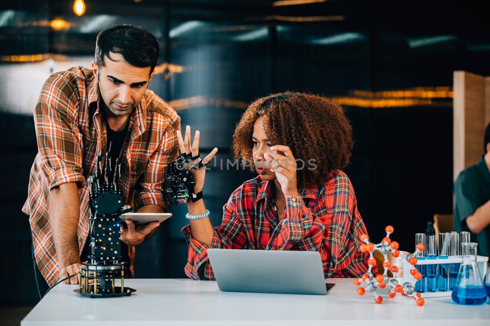 In a classroom a teacher mentors a student crafting a robotic arm for design and technology lessons. Nurturing innovation discovery and coding skills with enthusiasm. Robot hand. technology concept