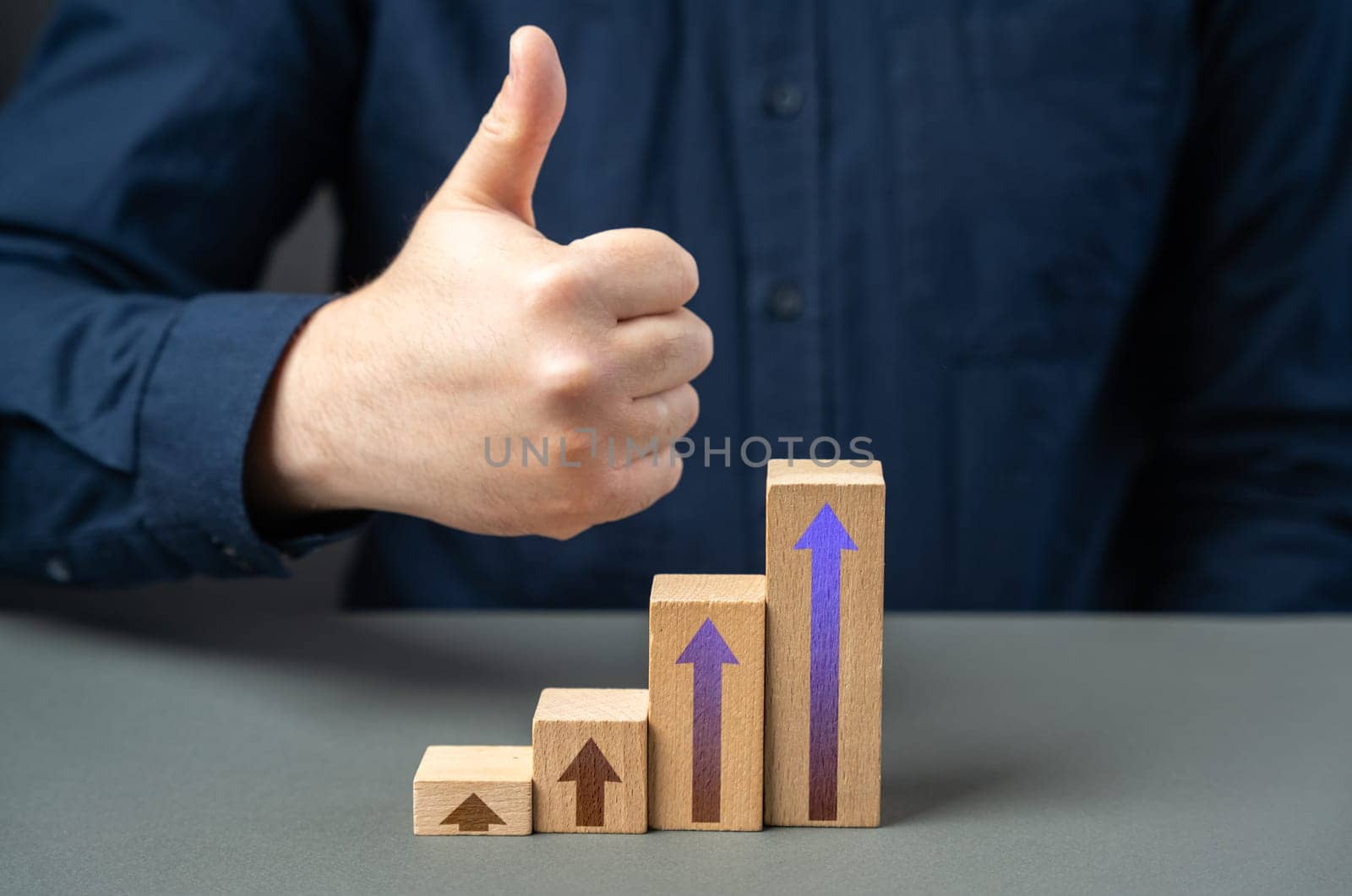 A man shows a thumbs up from a success graph. Successful investments. Income and economic development. Optimistic forecast. Entrepreneurship.