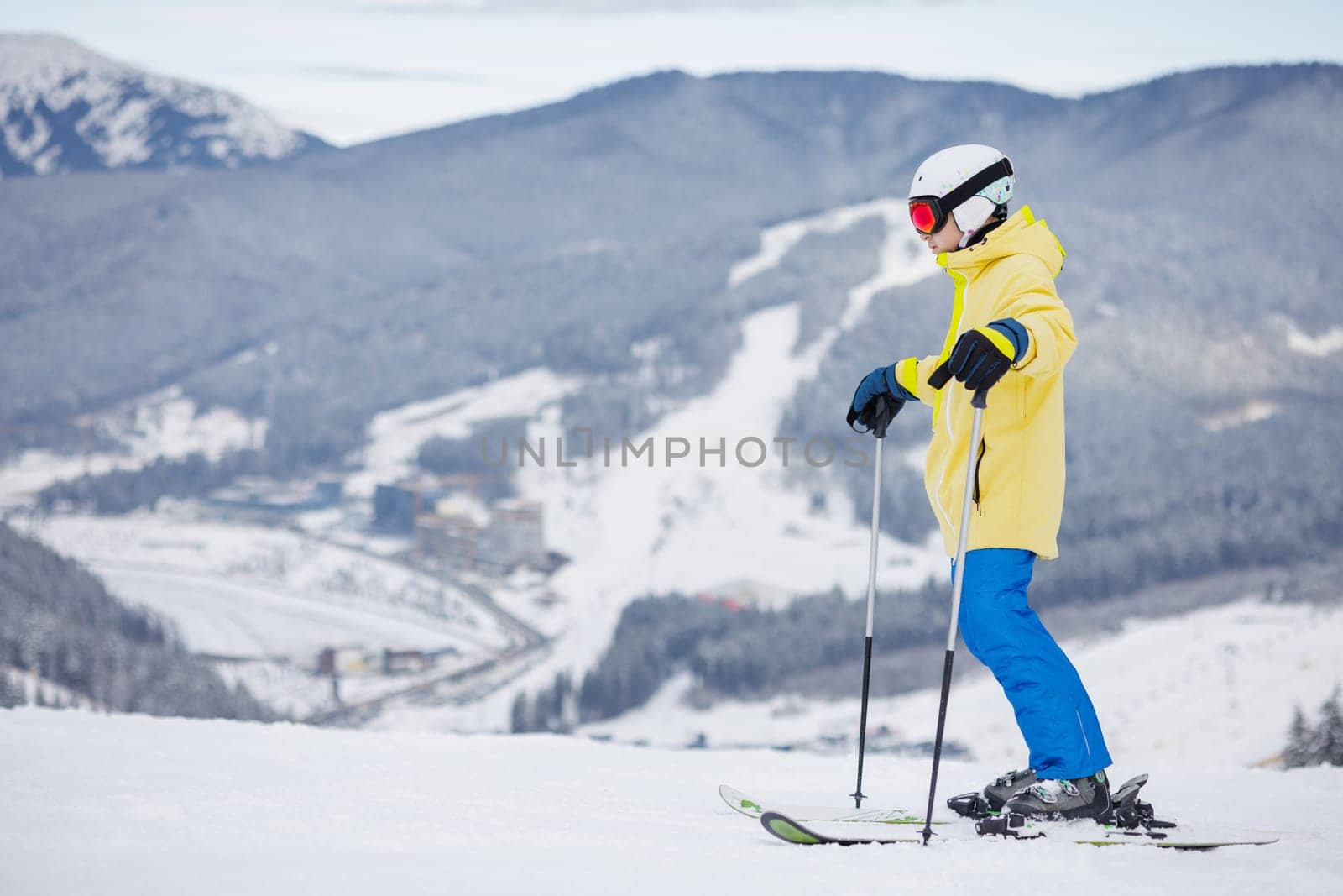 happy skier with bright sports suit on background of beautiful snowy mountains,