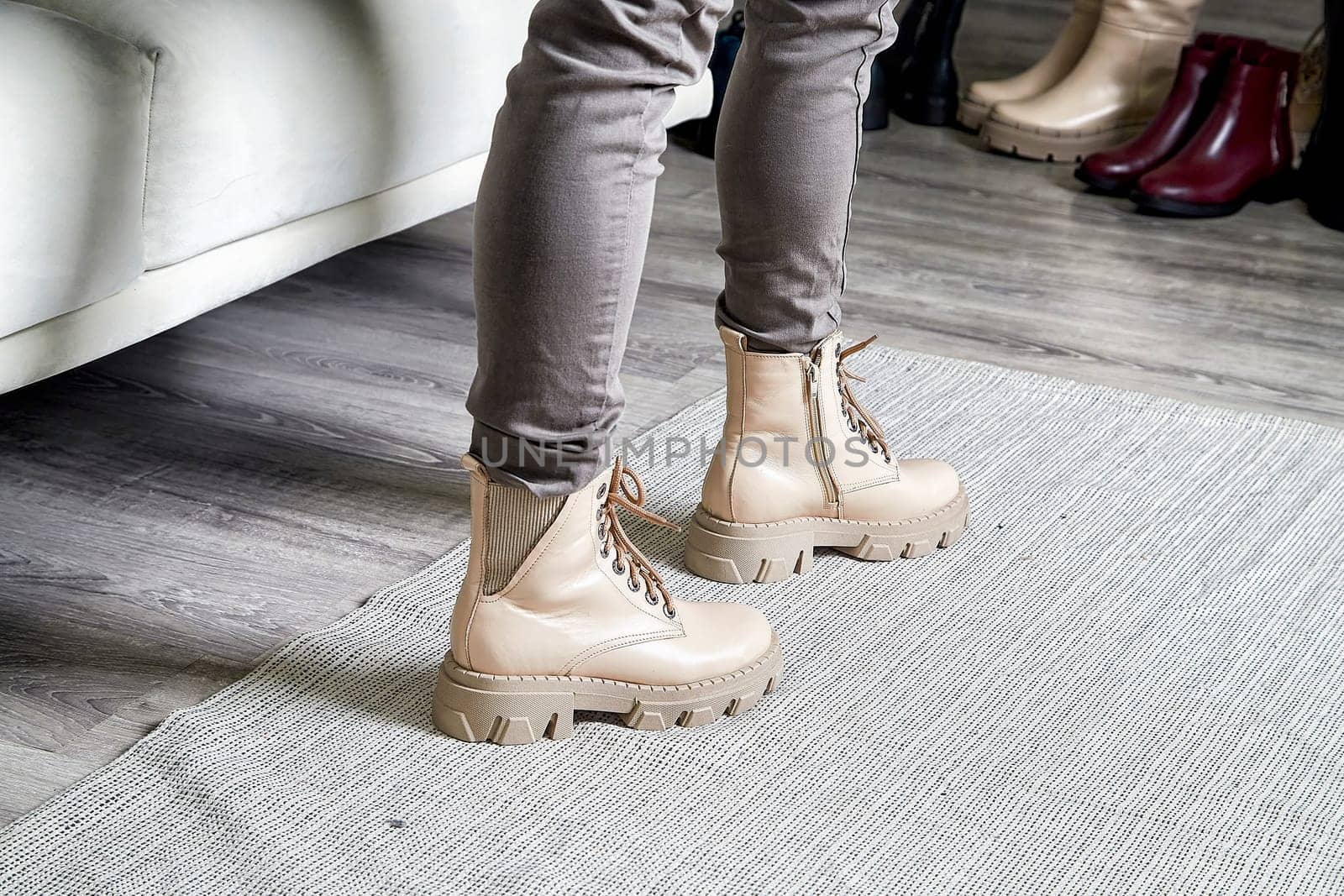 Model poses confidently in trendy shoes, highlighting the latest fashion style in a cozy indoor environment.