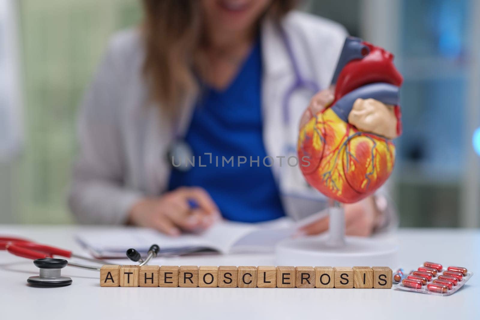 A dedicated healthcare professional diligently studying atherosclerosis using a heart model and various medical tools