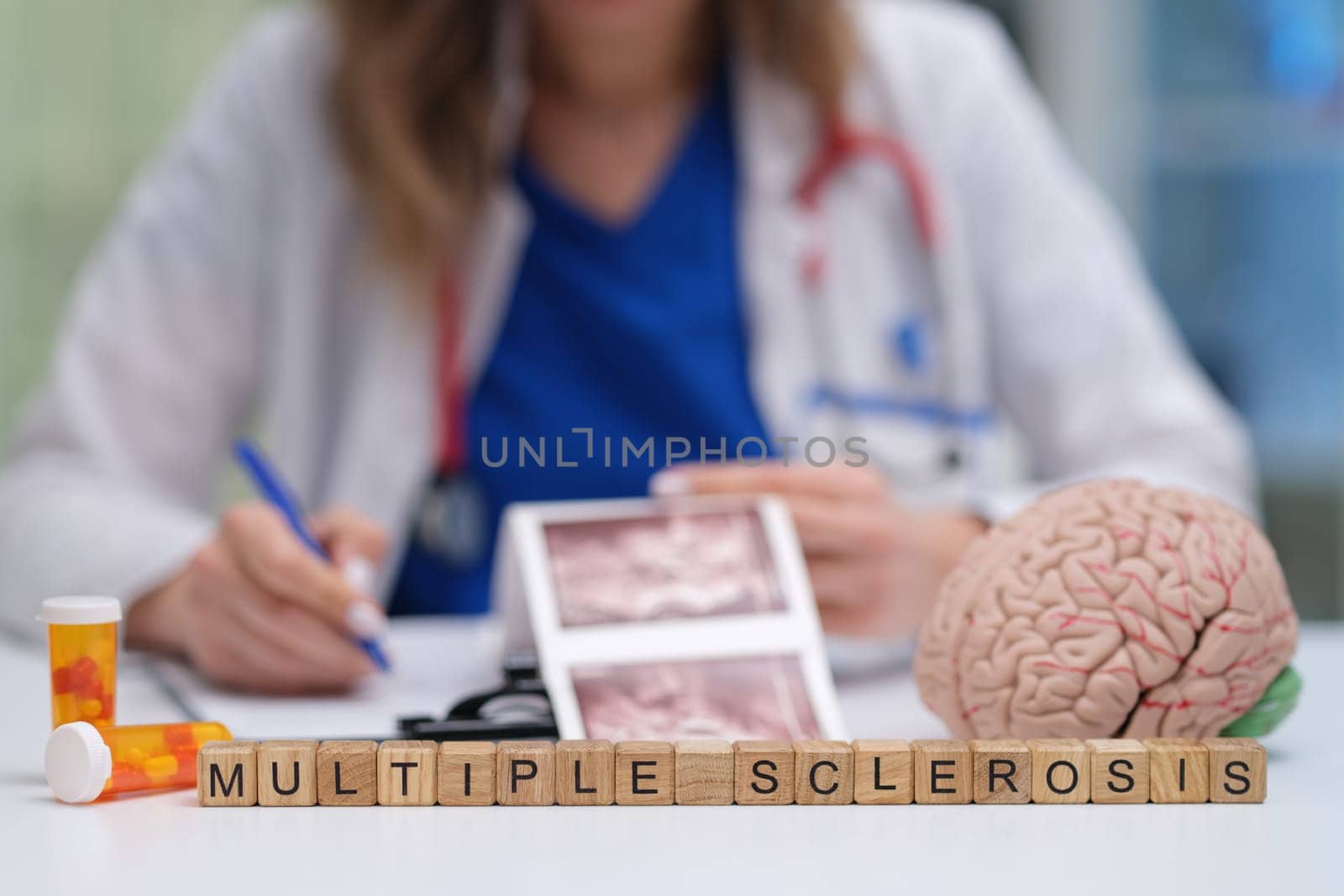 A healthcare professional is carefully analyzing medical images that are related to multiple sclerosis and its effects