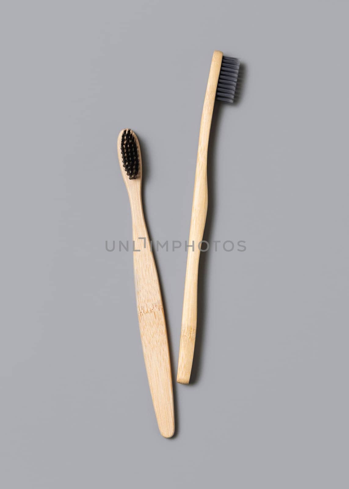 Two biodegradable bamboo toothbrushes on a light gray background top view, copy space. Zero waste and no plastic concept.
Natural personal accessories for tooth care, minimal style aesthetic flatlay