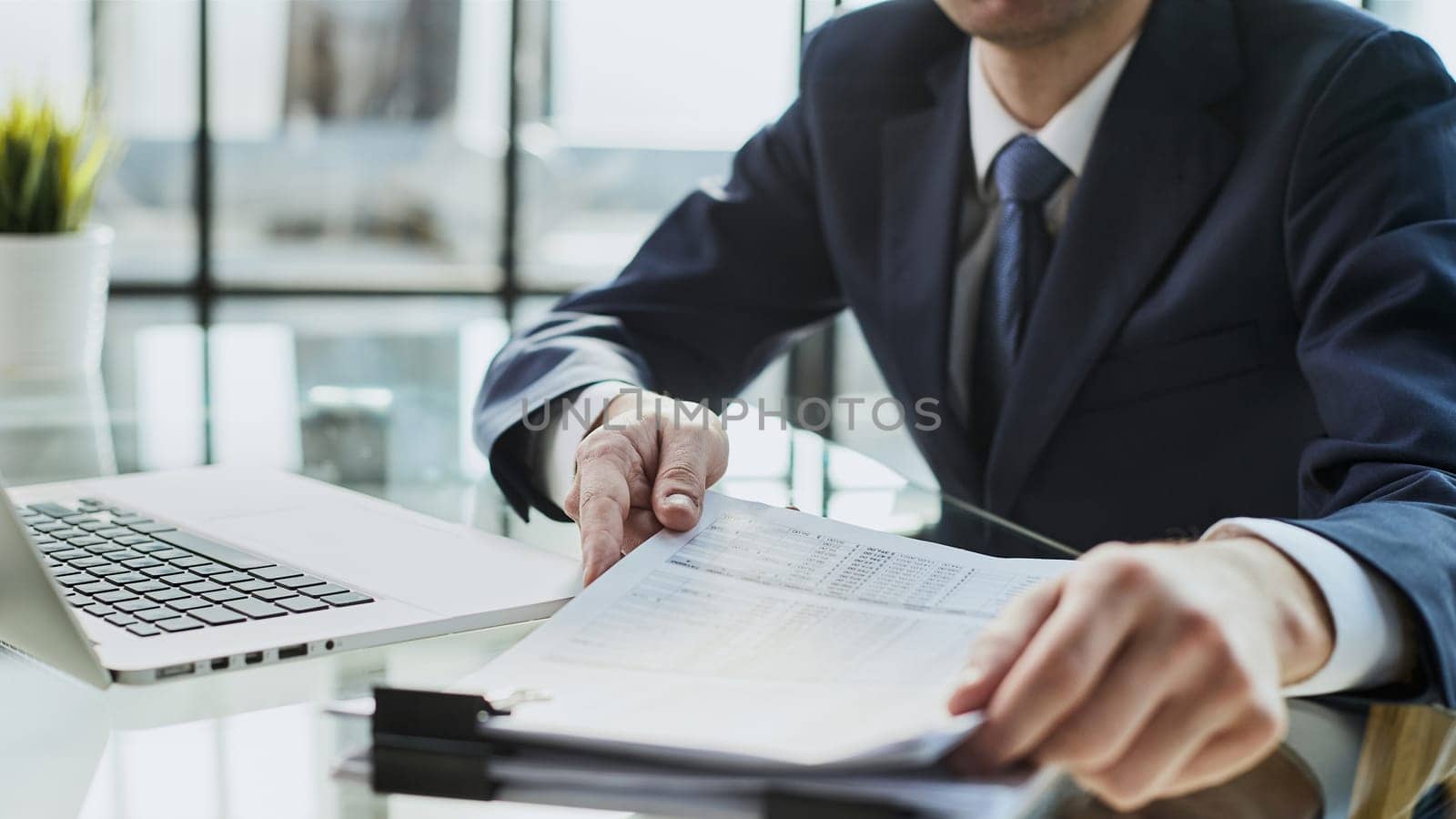 Close-up Of A Businessman Analyzing Financial Report In The Office