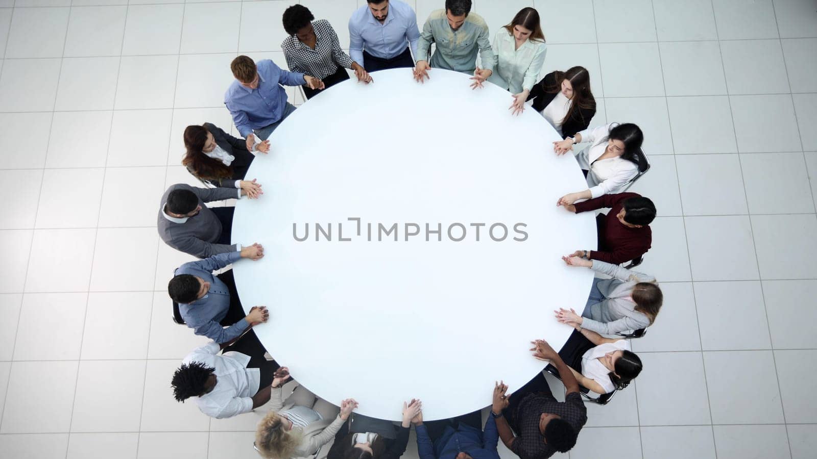 Top view of group of multiethnic busy people working in office, aerial view of sitting at negotiating table