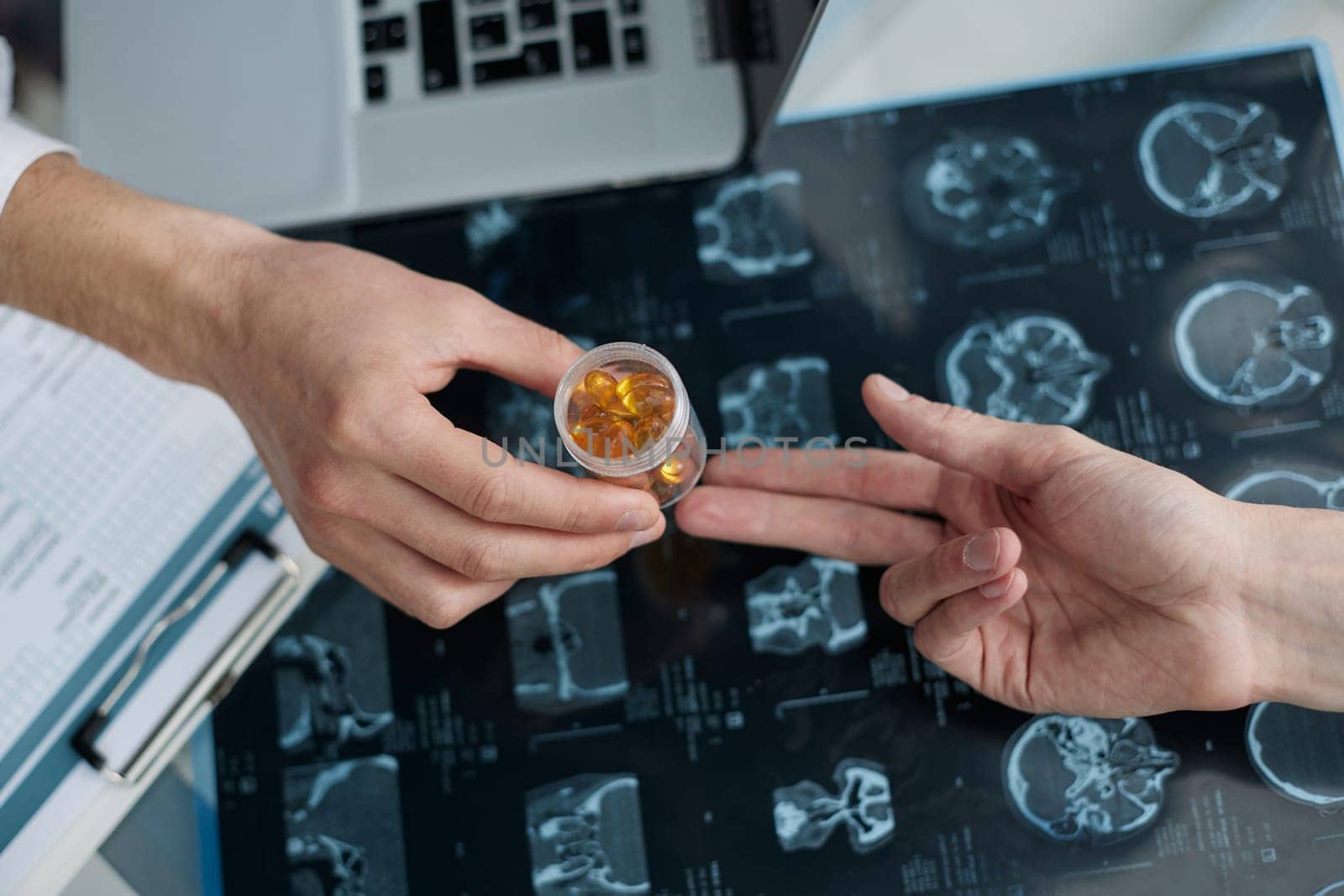 Close-up of hands of a doctor giving medicine to a patient on the background of an x-ray
