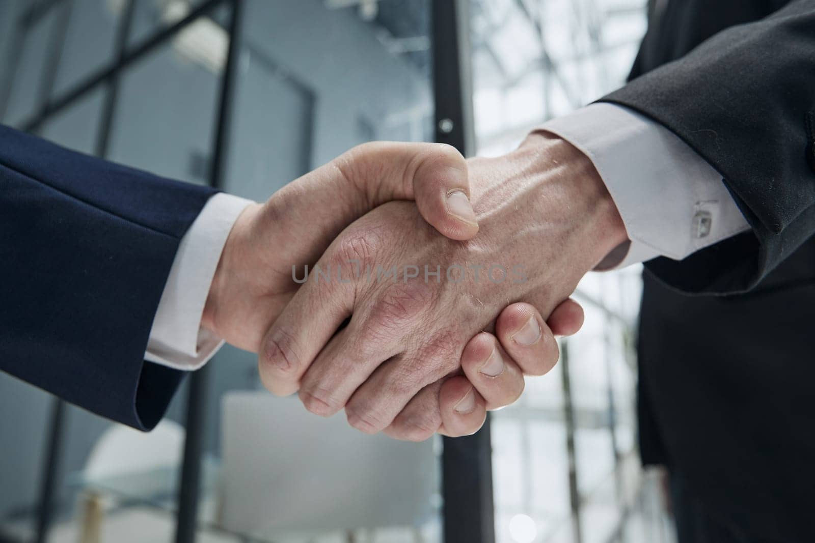 Handshake of two businessmen in a conference room, close-up