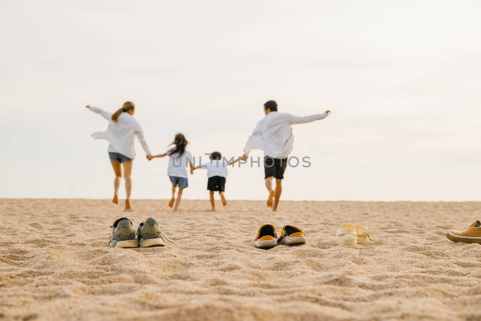 Happy family day. lifestyle father, mother and kids take off shoes running on sand, Back view Asian having family parents with child fun holding hands together run to beach, tropical summer vacations