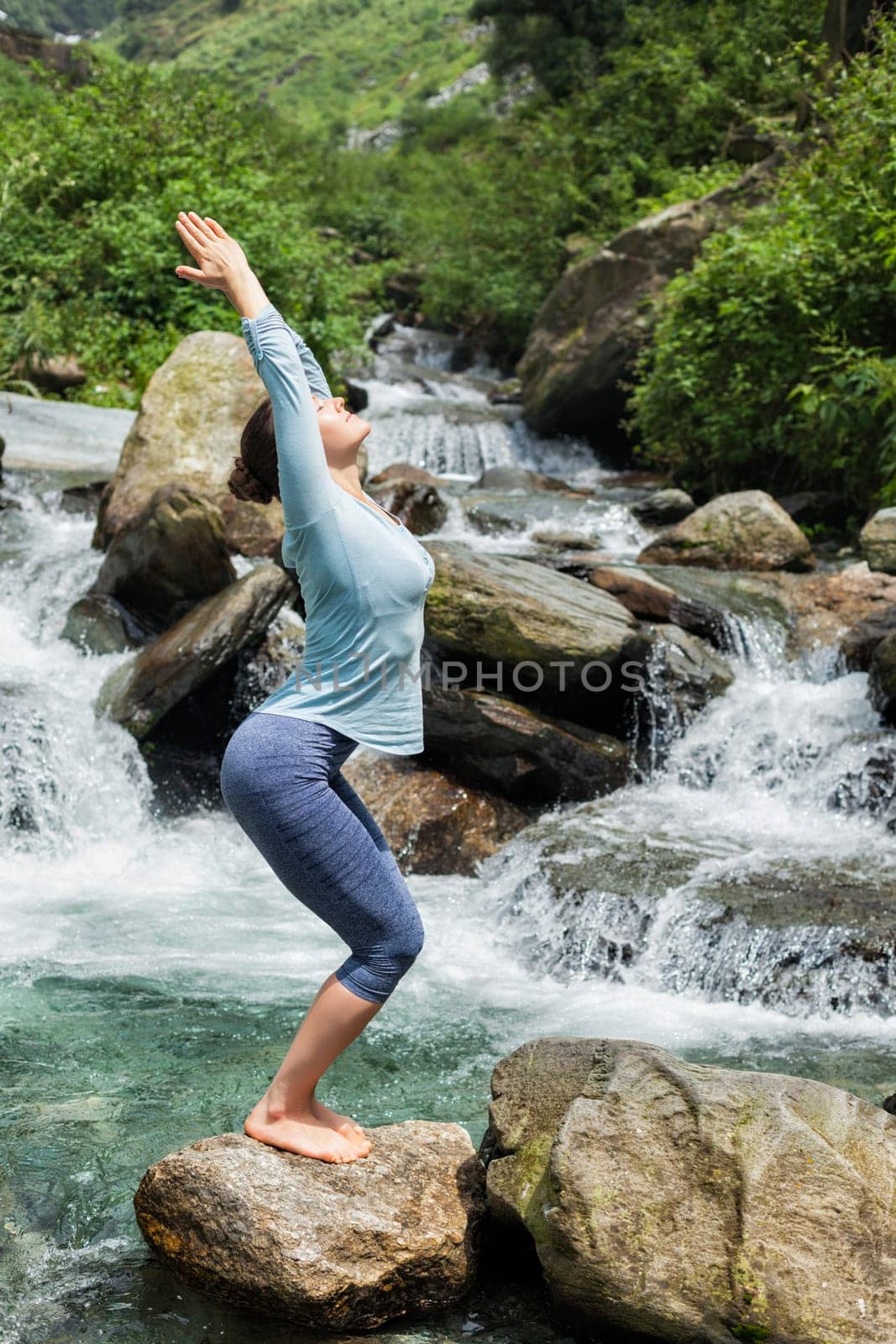 Sorty fit woman doing yoga asana Utkatasana by dimol