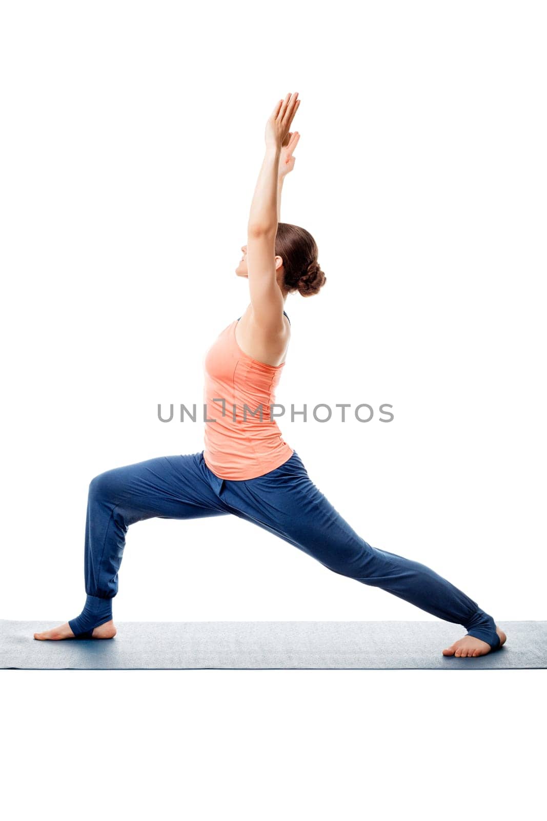 Beautiful sporty fit yogini woman practices yoga asana Virabhadrasana 1 - warrior pose 1 isolated