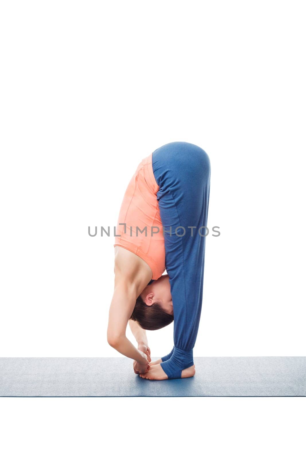 Woman doing Ashtanga Vinyasa Yoga asana Padangushthasana - standing forward bend hand to toe pose posture isolated on white background