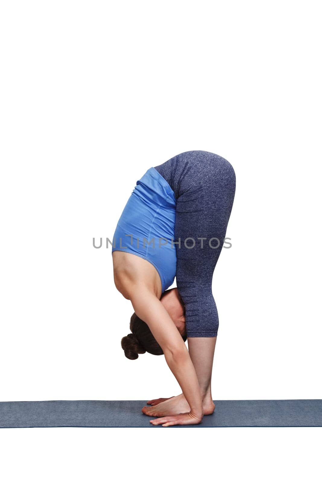 Woman doing yoga asana Uttanasana - standing forward bend by dimol
