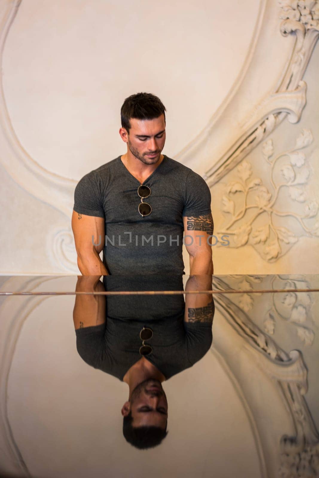 Photo of a man standing in front of a glass table by artofphoto