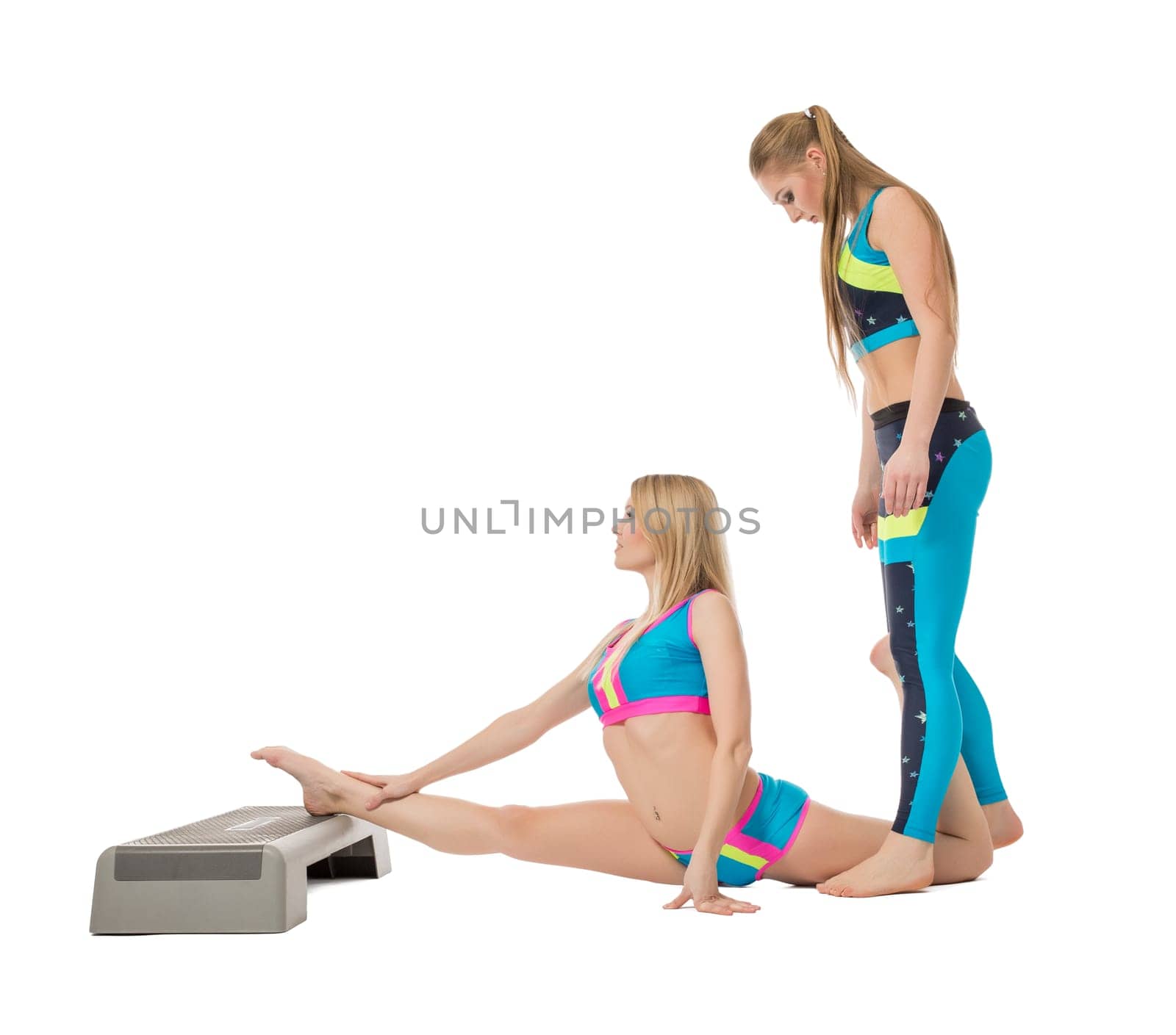 Pretty female gymnasts warming up in studio, isolated on white