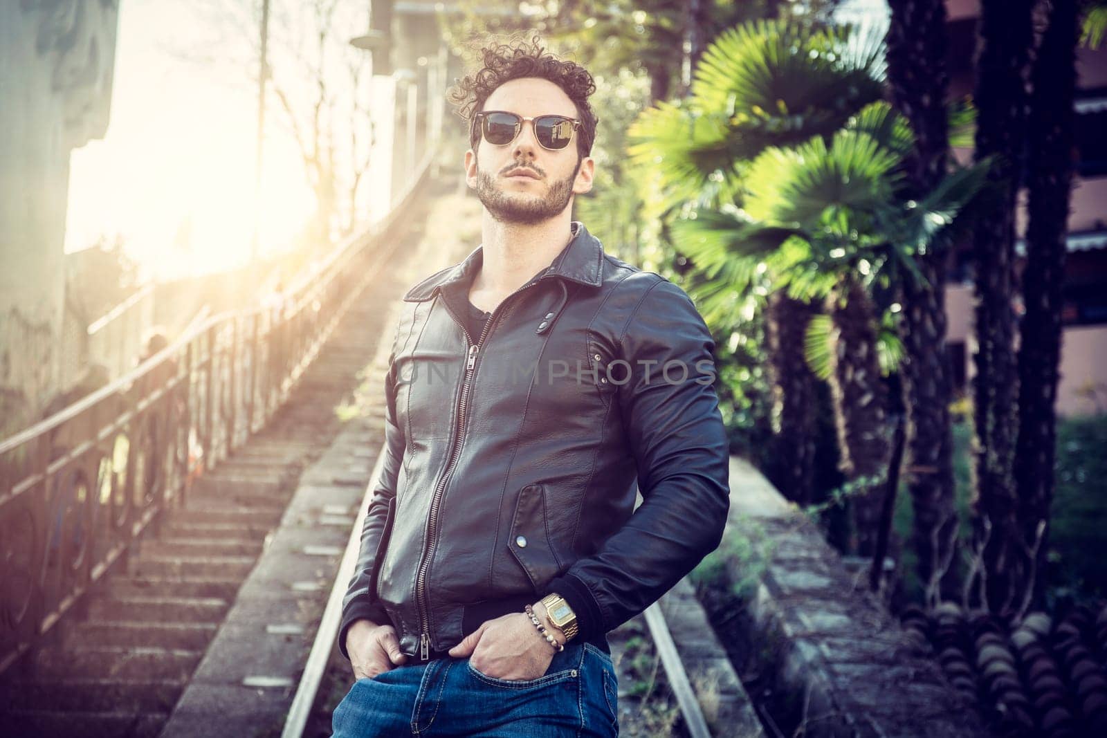 A man standing in front of a train track. Photo of a man standing in front of a train track