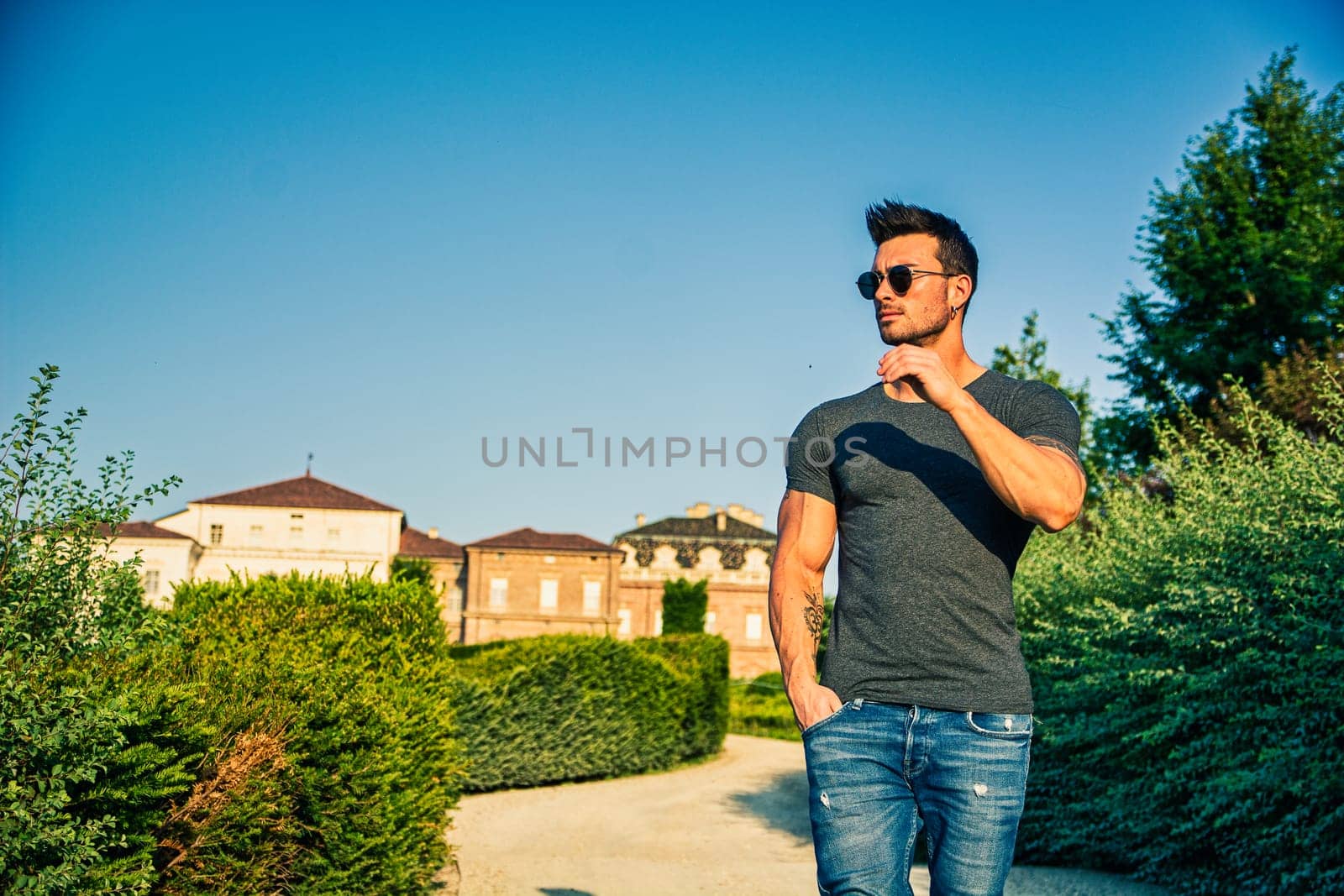 A man standing on a dirt road with trees in the background. Photo of a man standing on a dirt road surrounded by trees