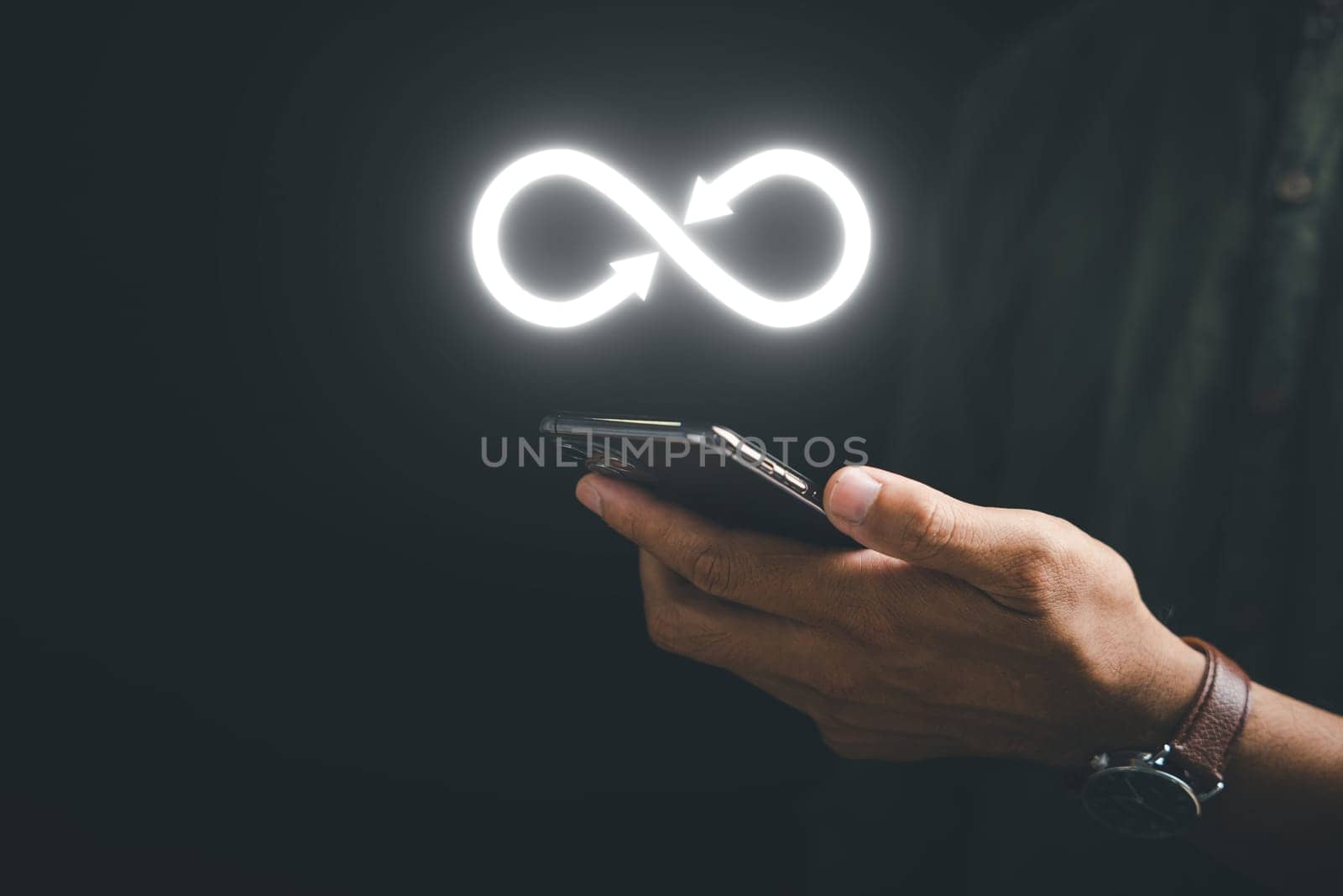 Businessman displays smartphone with infinity symbol, indicating unlimited connection in data technology. Cyber space, future unlimited. Infinite, internet information. technology infinity data