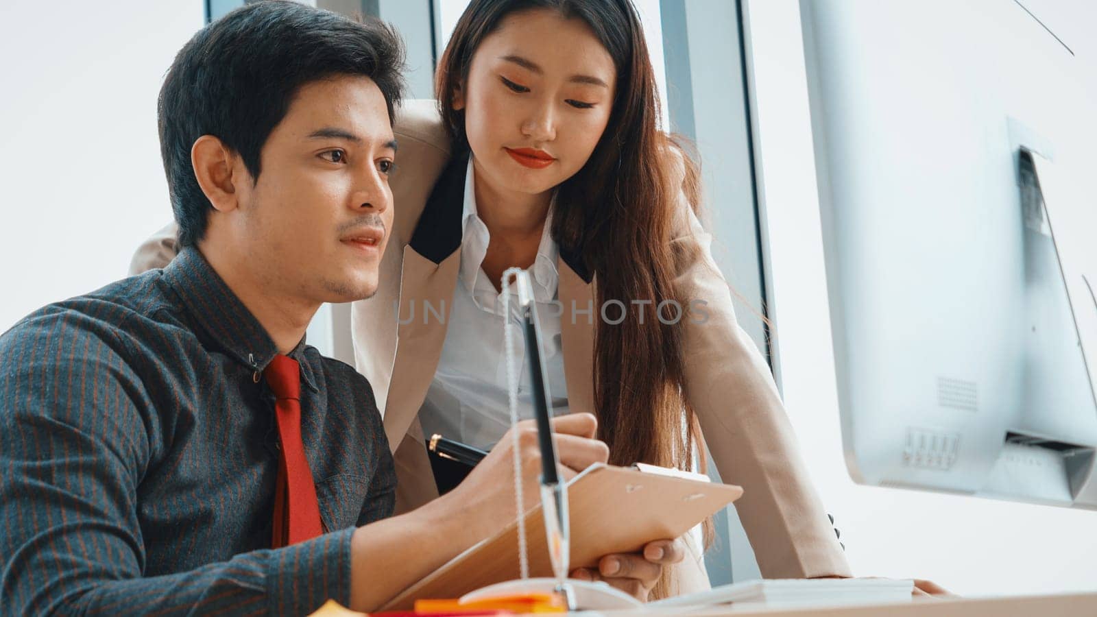 Two business people talk project strategy at office meeting room. Businessman discuss project planning with colleague at modern workplace while having conversation and advice on financial report. Jivy