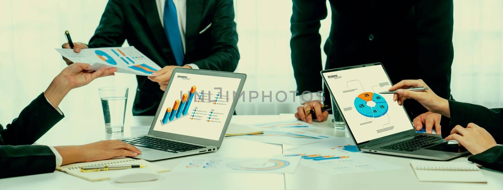 Business people in group meeting in formal attire share idea discussing report for company profit in creative workspace for start up business shot in close up view on group meeting table . Oratory .