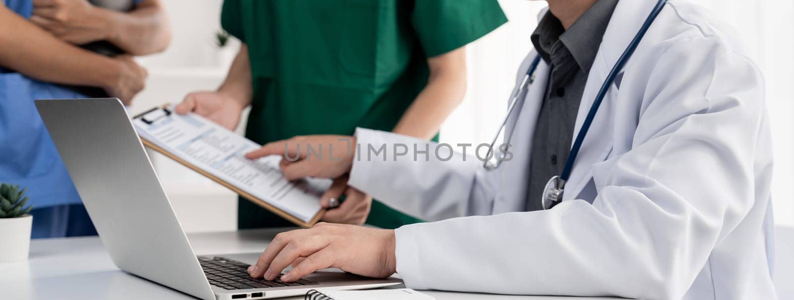 Professional various team of medical working and planning medical treatment at hospital table together. Teamwork lead to successful illness and sickness treatment. Panorama Rigid