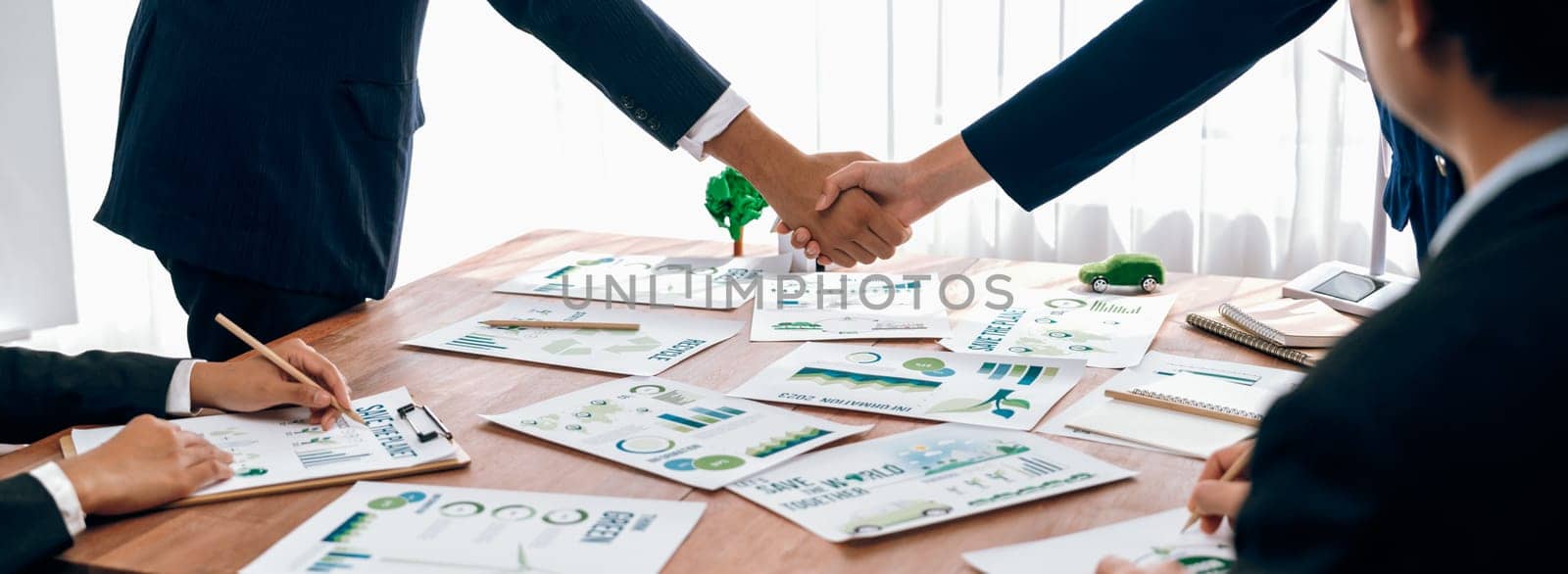 Business people hand shake in Eco corporate meeting room after made successful agreement deal on eco-friendly products. Sustainability and environmental protection in business cooperation.Trailblazing