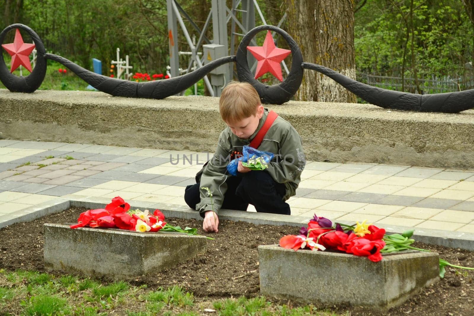 PYATIGORSK, RUSSIA - MAY 09, 2011: Boy lay flowers to the monument to the fallen soldiers of Second World War Victory Day