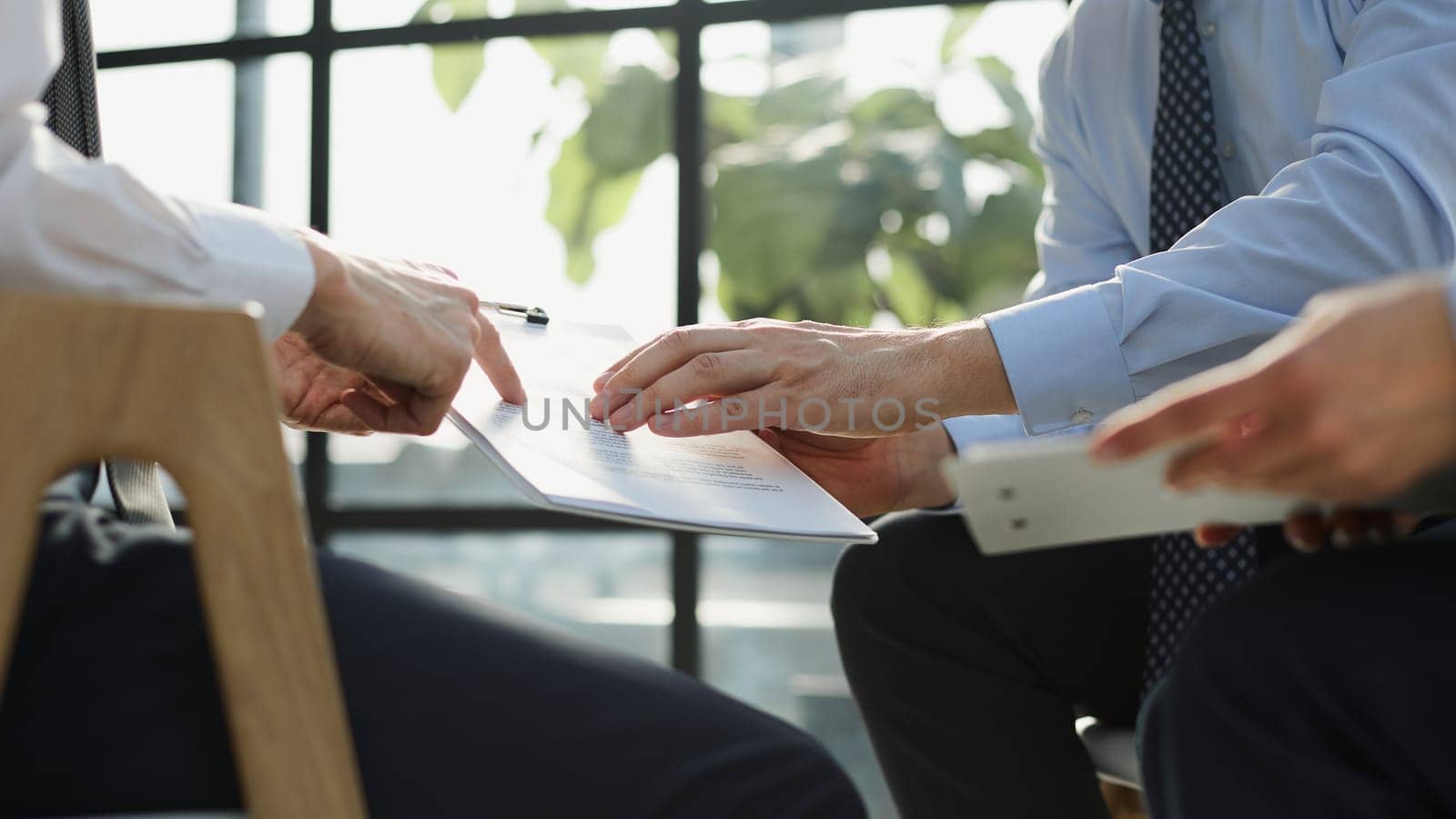 Two business employees reviewing documents in open folder. Paperwork concept