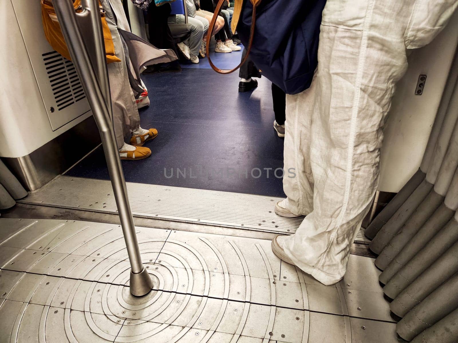 Hong Kong, China - April 09, 2024 - Passengers ride the subway in Hong Kong, surrounded by a mix of attitudes and activities during busy travel times.
