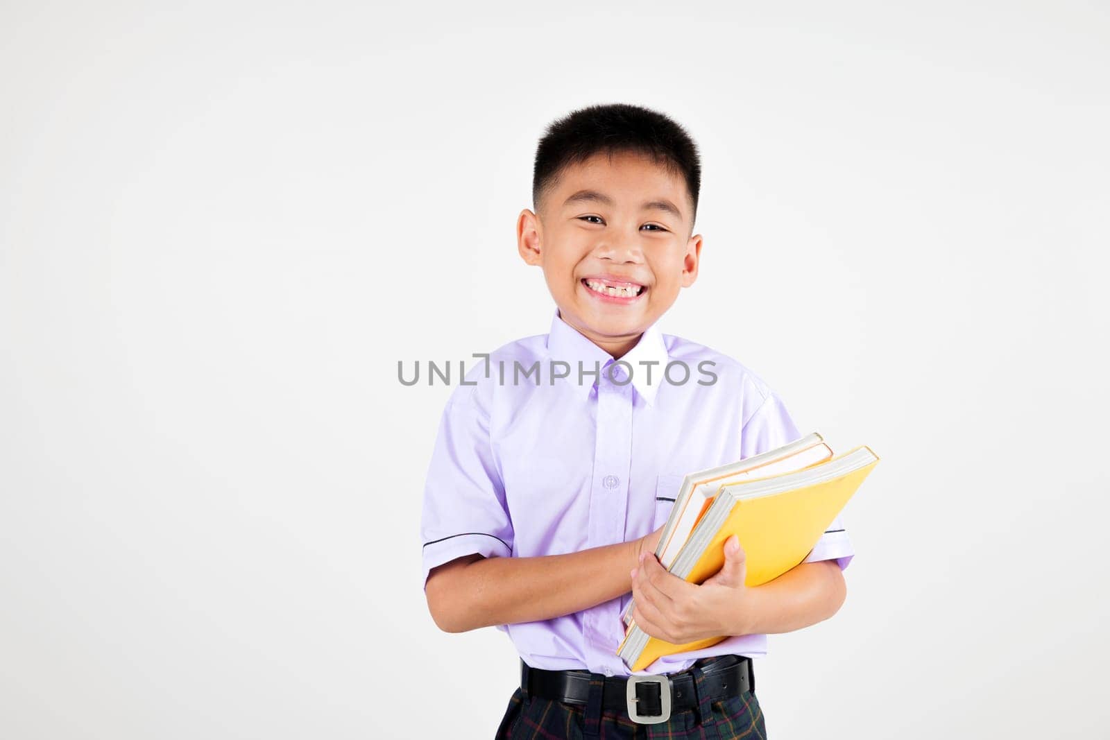 Portrait smile Asian little boy primary posing hand holding book studio isolated white background, happy cute man kid wear school uniform plaid, back to school concept