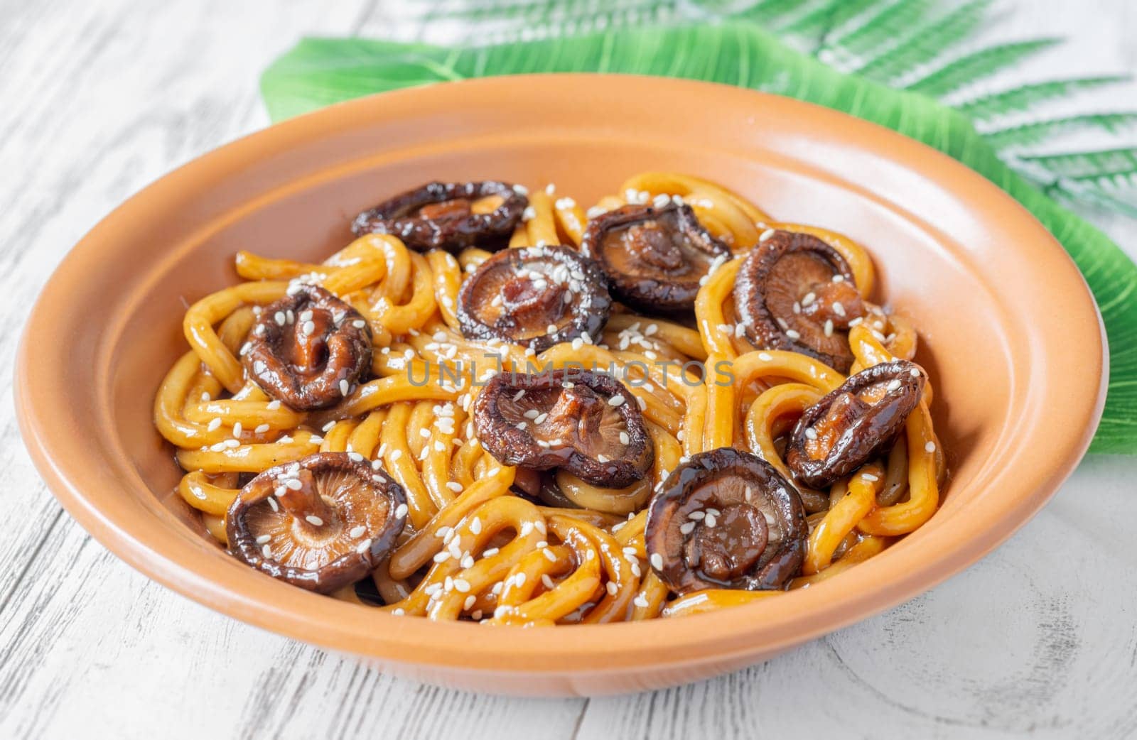 A portion of udon noodles with soy unagi mirin ginger sauce, shiitake and enoki mushrooms, and green onion