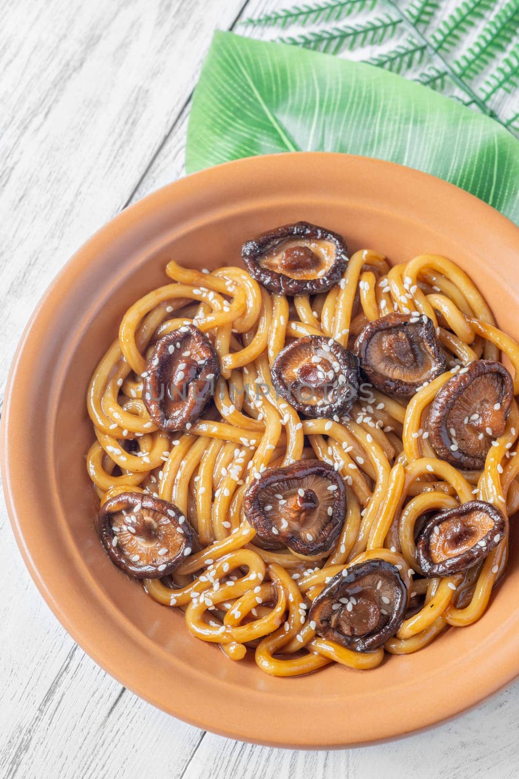 A portion of udon noodles with soy unagi mirin ginger sauce, shiitake and enoki mushrooms, and green onion
