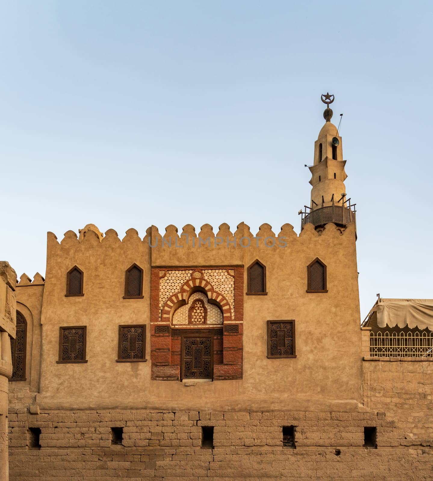 Abu Haggag mosque with a detailed entrance and a tall minaret under a clear sky and built inside the Luxor temple