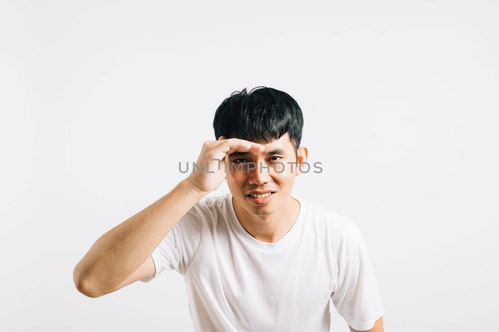 Portrait Asian smiling young man trying to see something into distance holds palm on forehead studio isolated white background, Happy lifestyle men carry person hand and search in distance