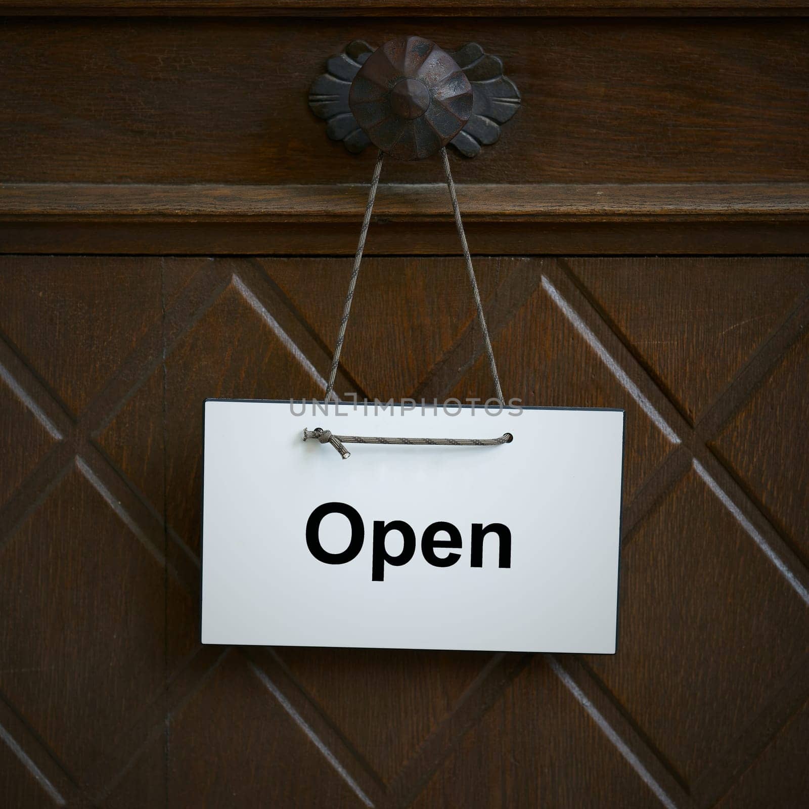 Sign on an entrance door with the English word open