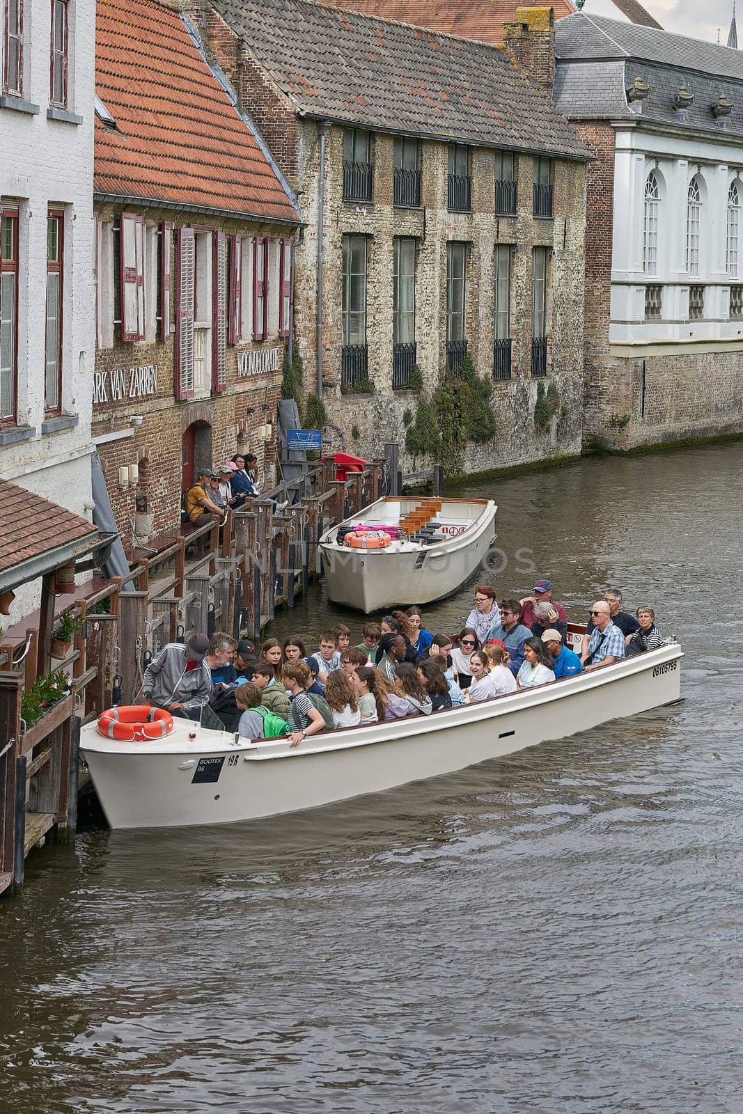 Bruges, Belgium – May 13, 2024: Canal in the old town of Bruges with excursion boats for tourists