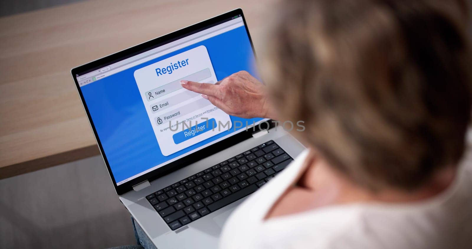 Businesswoman's Hand Filing Online Registration Form On Laptop