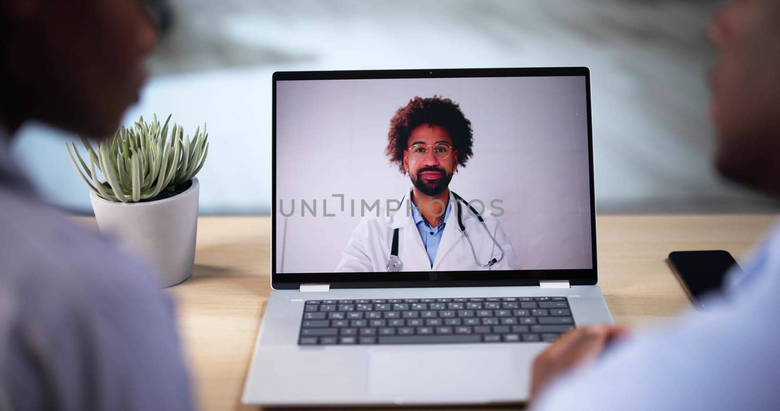 Pregnant Couple In Online Video Conference Call With Doctor