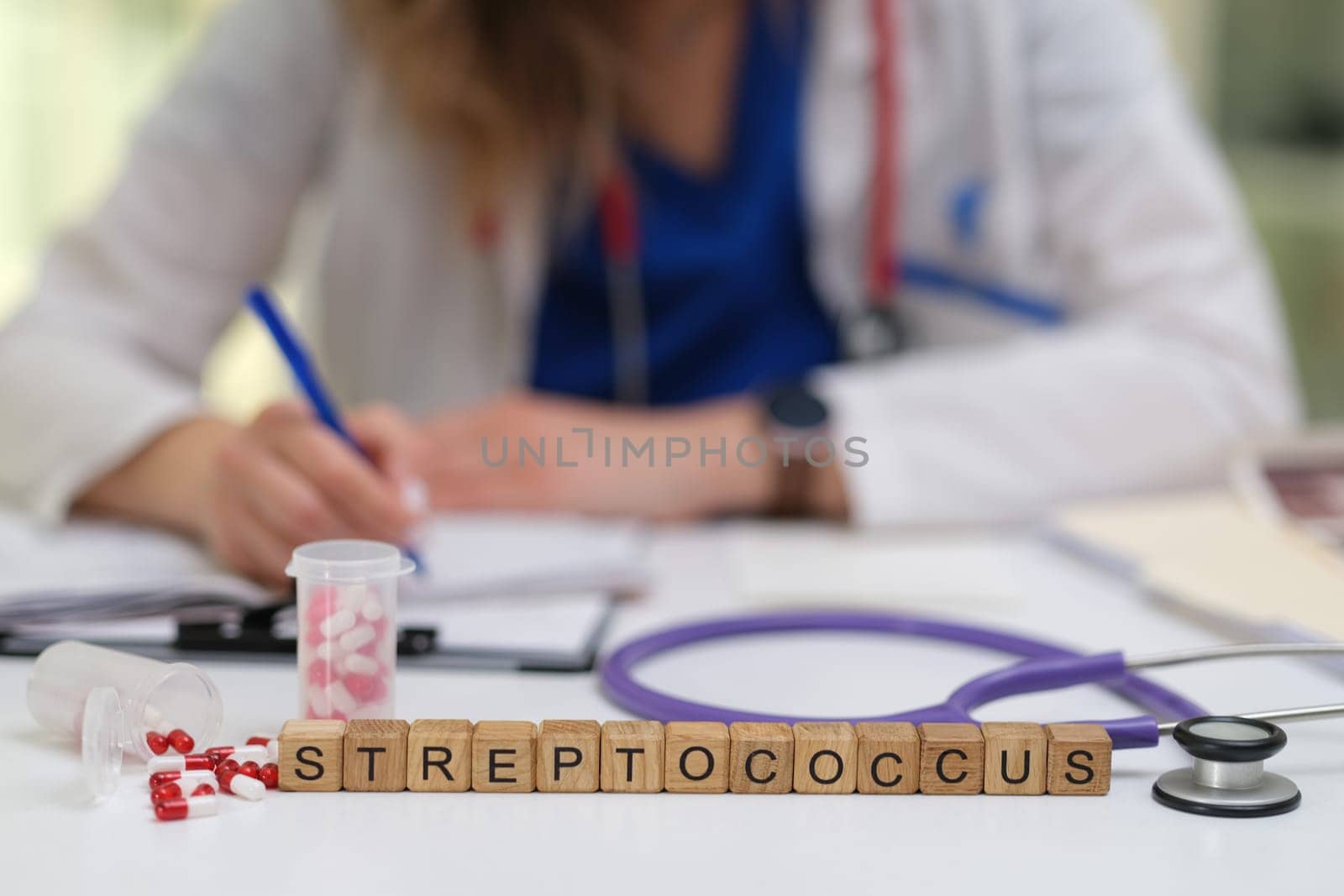 A skilled healthcare professional observes and notes important details focusing on Streptococcus bacteria at the table