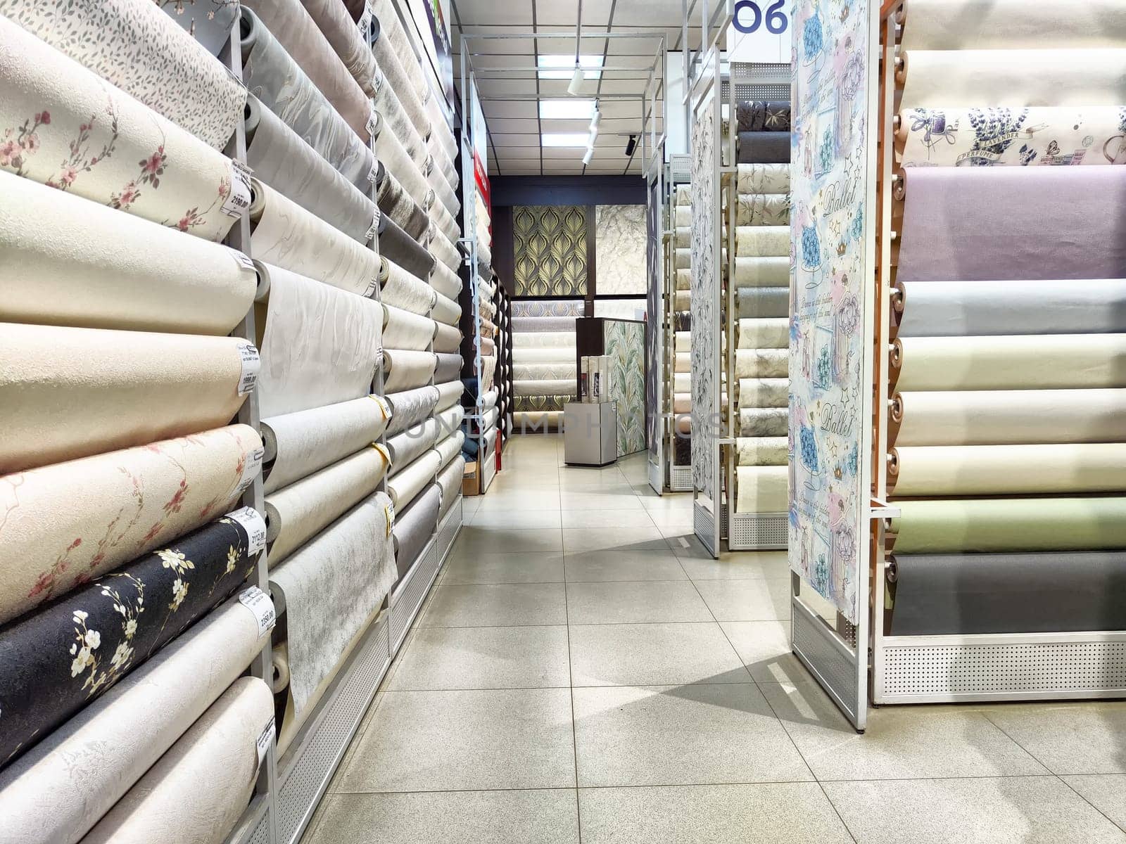 Kirov, Russia - August 08, 2023 - Colorful wallpaper rolls are neatly arranged in a store aisle, showcasing a wide selection for home decor enthusiasts.