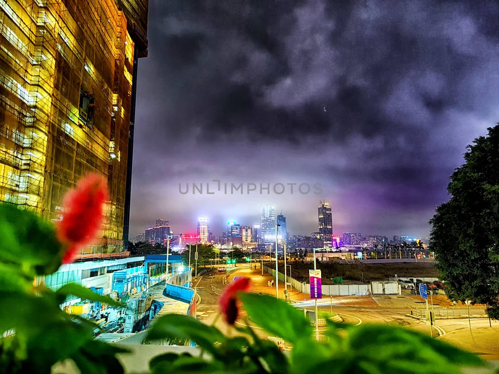 Hong Kong, China - April 06, 2024 - Vibrant city lights adorn Hong Kong's skyline at night, showcasing tall skyscrapers and urban life seen from a nearby viewpoint.