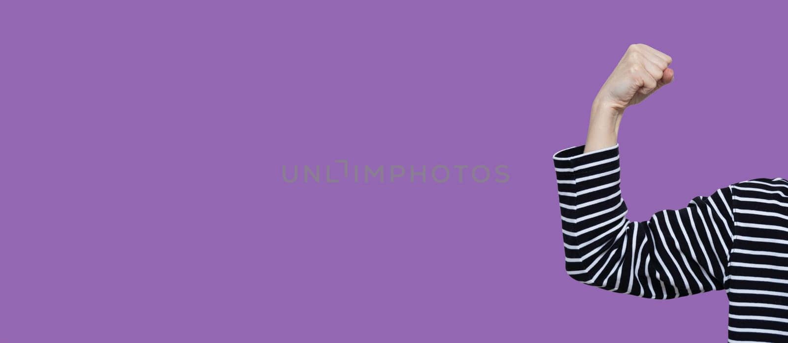 Banner IWD2025 Accelerate action. AccelerateAction. International Women's Day. 8 march day. Faceless Women's hand on purple background. Strong, power, strength demonstrate.
